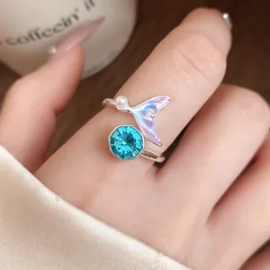 Vue rapprochée détaillée d'une bague sirène élégante en argent avec zircon bleu et perle fine