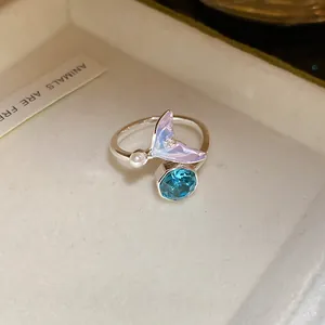 Gros plan détaillé d'une bague queue de sirène en argent avec un zircon bleu facetté