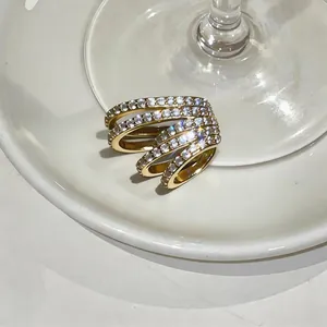 Detailed macro view of a gold-plated multi-layer ear cuff featuring sparkling pavé zircons