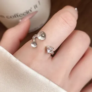 Gros plan d'une bague ouverte minimaliste en argent avec une pierre de zircon portée au doigt