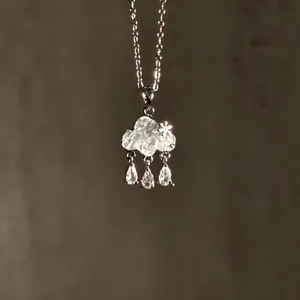 Macro view of cloud pendant necklace with sparkling zircon droplets and silver chain