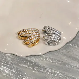 Detailed view of gold and silver multi-layer ear clips with pavé cubic zirconia