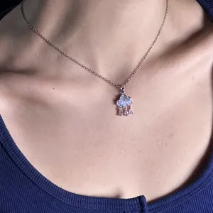 Detailed close-up view of light blue cloud pendant necklace with zircon charms on model