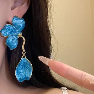 Vintage style blue enamel flower drop earrings with detailed textured golden frame