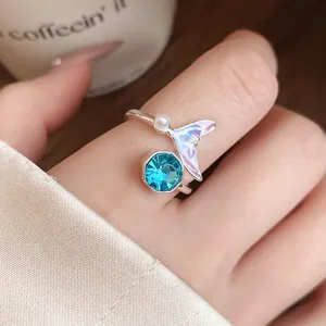 Détail d'une bague sirène ajustable élégante avec un cristal bleu brillant et perle.