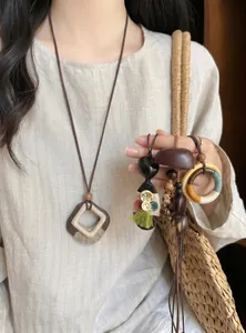 Detailed close-up showing diverse Bohemian style wooden seed necklaces on linen outfit