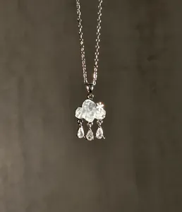 Close-up detail of light blue cloud pendant necklace with shimmering zircon rain drops