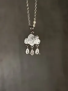 Detailed close-up view of an elegant cloud-shaped necklace with teardrop zircon raindrops