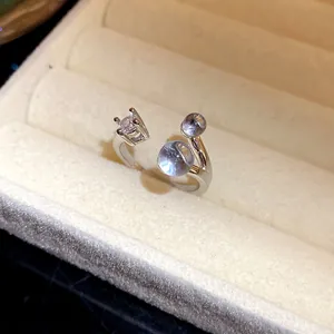 Vue détaillée d'une bague ouverte en argent avec un zircon et deux pierres bleues.