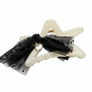 Elegant star-shaped hair claw clip with black mesh polka-dot bow and silver heart pendant detail