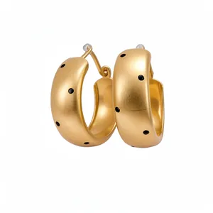 Elegant gold-colored chunky hoop earrings with black polka dots and premium matte finish.