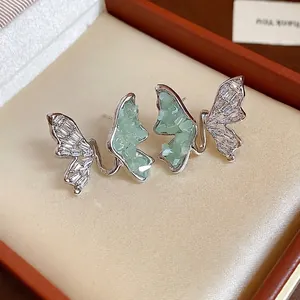 Boucles d'oreilles papillon en argent avec cristaux verts et zircons dans un écrin cadeau