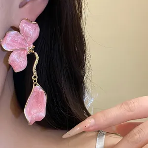 Detail view of elegant pink enamel flower drop earrings with a stylish golden trim