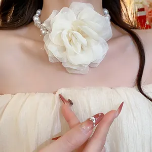 Detailed view of an elegant summer chiffon flower pearl necklace worn on a model's neck