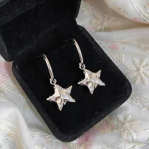 Vista macro dettagliata di orecchini a stella in argento con eleganti zirconi brillanti