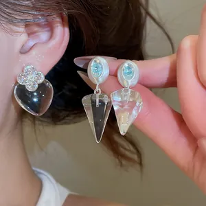 Détail de boucles d'oreilles transparentes en forme de cœur et de cône élégantes