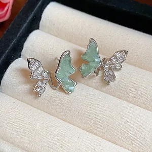 Gros plan de boucles d'oreilles papillon avec zircons et pierres vertes