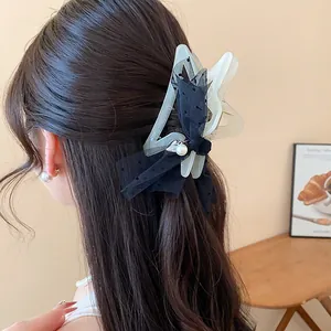 Close-up detail of elegant black polka dot mesh hair claw clip worn on dark brunette hair