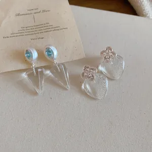 Détail de boucles d'oreilles transparentes en forme de cœur et de cône coréen
