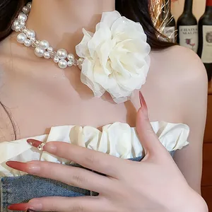 Close-up of elegant chiffon flower pearl necklace with glass beads on model