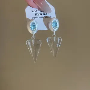Détail macro de boucles d'oreilles coréennes en forme de cône de cœur avec base argentée.
