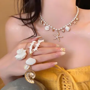 Elegant pearl necklace with seashell and starfish charms on a model