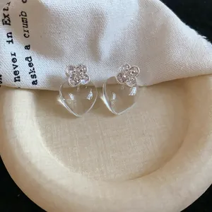 Détail des boucles d'oreilles coréennes en forme de cœur transparent avec trèfle en cristal