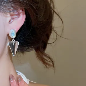 Gros plan détaillé de boucles d'oreilles pendantes coniques transparentes style coréen