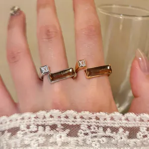 Close-up of minimalist geometric rings in gold and silver featuring amber stones
