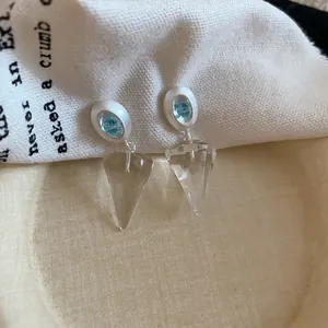 Vue détaillée de boucles d'oreilles cône transparent avec des accents de pierres bleues