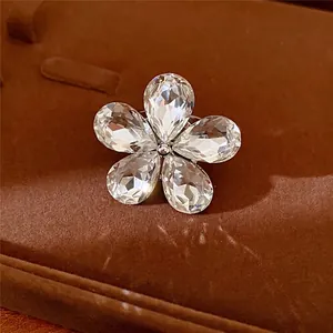 Elegant rhinestone flower open ring with sparkling crystal petals on brown velvet