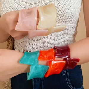 Colorful resin marbled irregular geometric twisted open bangles on model's arms