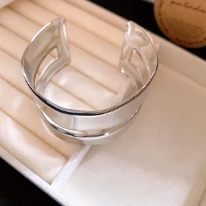Close-up of a silver double-layer irregular open cuff bracelet in a jewelry tray.