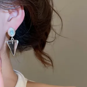 Gros plan de boucles d'oreilles coréennes en pyramide transparente avec perles