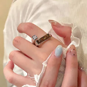 Close-up of 18k gold plated geometric ring with white and brown crystals.
