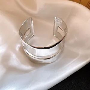Close-up detail of a minimalist polished silver double-layer irregular cuff bracelet