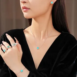 Elegant luxury jewelry set featuring square blue zircon necklace, earrings, and rings on model