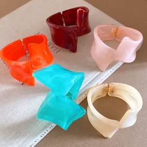 Detail view of irregular geometric resin bangles with a marble effect in vibrant colors