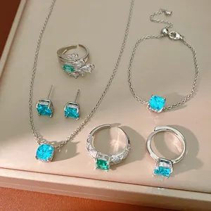 Close-up of geometric square blue zircon jewelry set including necklace and rings