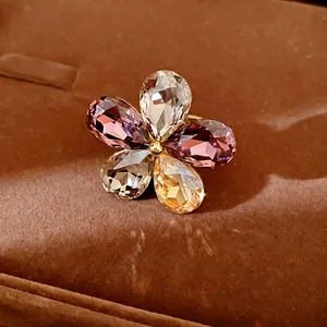 Macro detail of a fashion crystal flower ring with multi-colored teardrop stones on velvet