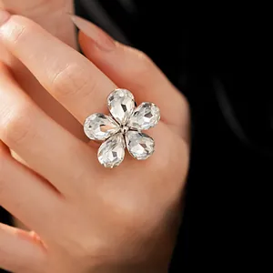 Close-up of elegant five-petal rhinestone flower ring on hand, macro jewelry detail