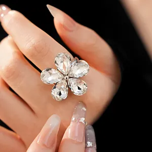 Close-up detail of a sparkling five-petal flower rhinestone open ring on hand