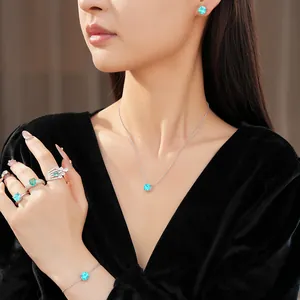 Elegant close-up of blue zircon geometric jewelry set on model in black velvet
