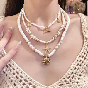Layered white beaded necklace with gold starfish and shell pendants on female neck