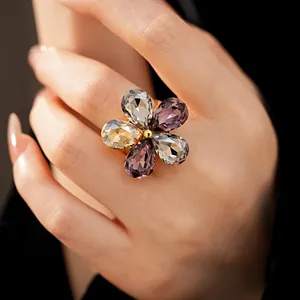 Detailed macro view of an elegant flower ring with faceted crystals on a model finger.