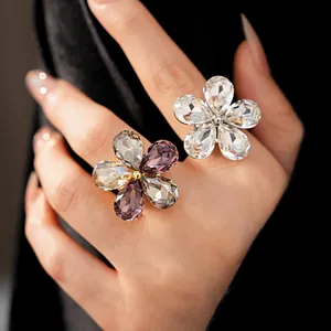 Close-up of oversized floral crystal open rings with sparkling stones on a model's hand