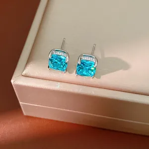 Elegant detailed view of light blue square zircon stud earrings resting on a jewelry box
