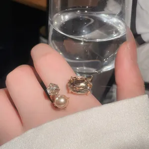 Detail view of a luxury champagne crystal open ring with pearl and sparkling accents