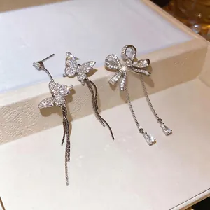 Sparkling zircon butterfly and bow earrings with long tassels on a display box