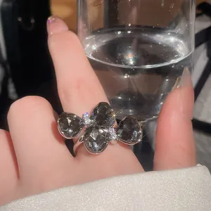 Close-up of silver-toned bow ring with dark grey teardrop stones and zircon accents.